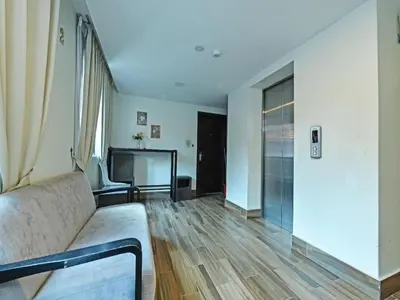a living room with a couch and a television at Capital O 90574 Hotel Glo in Kuala Lumpur