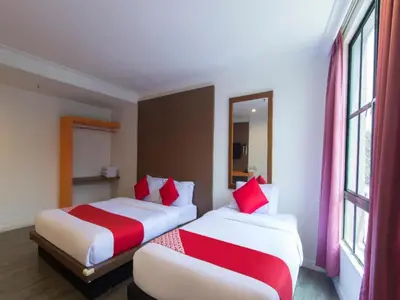 two beds in a hotel room with red and white pillows at OYO 1045 Azimuth Hotel in Kuala Lumpur