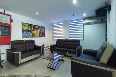 a waiting room with couches and chairs and a table at OYO 1045 Azimuth Hotel in Kuala Lumpur