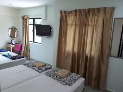 a bedroom with two beds and a tv and a window at Budget Star Hotel in Kuala Lumpur