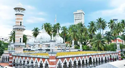 a mosque in a city with palm trees in the background at SPOT ON 89616 My Trillion Hotel in Kuala Lumpur