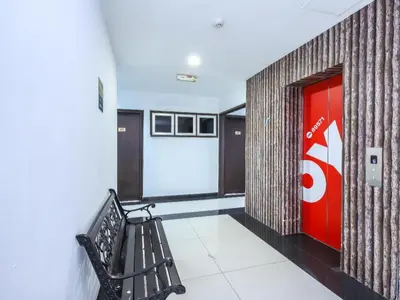 a hallway with a bench and a red door at OYO 89571 Eco Palace hotel in Kuala Lumpur