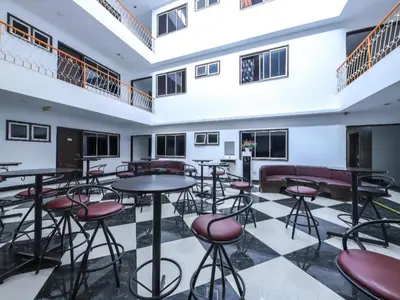 a room with tables and chairs and windows at OYO 89571 Eco Palace hotel in Kuala Lumpur