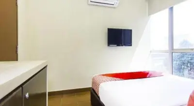 a room with a bed and a red chair at OYO 90429 Hotel Narasindo in Kuala Lumpur