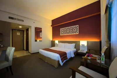a hotel room with a large bed and a desk at Grand Barakah Hotel in Kuala Lumpur