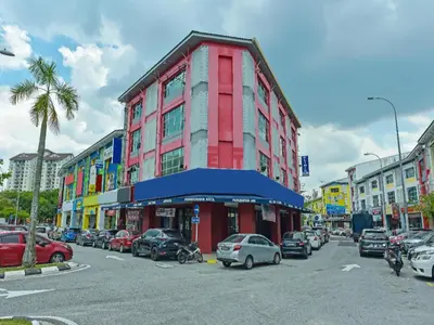 a red building with cars parked in a parking lot at Capital O 90788 New Hotel 33 Permaisuri in Kuala Lumpur