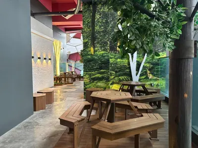 a restaurant with wooden tables and benches and plants at Arte Plus by Willow Trip in Ampang