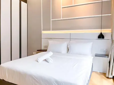 a white bed with white sheets and pillows at The Luxe by Manhattan Group in Kuala Lumpur