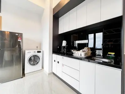 a white kitchen with a washer and dryer at The Luxe by Manhattan Group in Kuala Lumpur