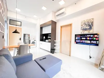a living room with a blue couch and a tv on a wall at The Luxe by Manhattan Group in Kuala Lumpur