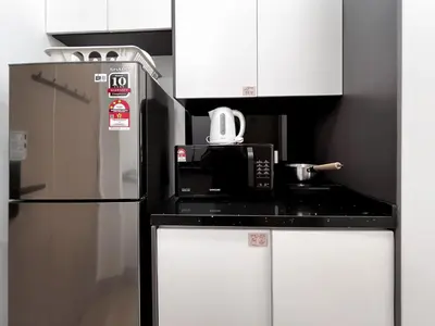 a kitchen with a microwave and a refrigerator at The Luxe by Manhattan Group in Kuala Lumpur