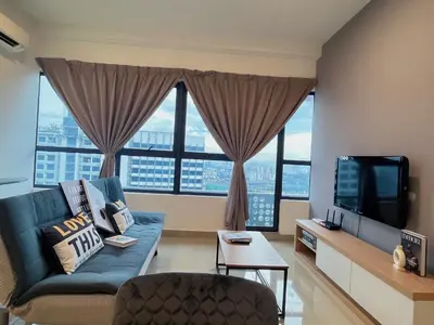 a living room with a blue couch and large windows at Arte Plus by Manhattan Group in Kuala Lumpur