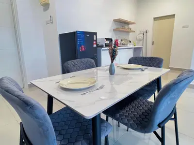 a dining room table with blue chairs and a white table at Arte Plus by Manhattan Group in Kuala Lumpur