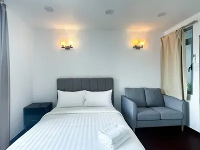a bedroom with a bed and a chair at Taragon Bukit Bintang City Centre in Kuala Lumpur