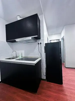 a kitchen with a sink and a black refrigerator at Taragon Bukit Bintang City Centre in Kuala Lumpur