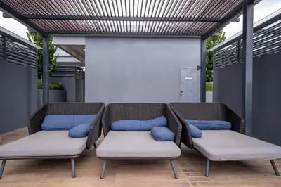 two wicker chairs with blue pillows on a patio at Neu Suites By Cozy Unit L30RB 2PAX near KLCC & Jelatek LRT in Kuala Lumpur