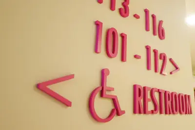 a clock on a wall with pink letters on it at Hotel Mezzo in Kuala Lumpur