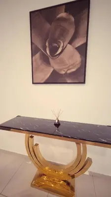 a black and gold table with a picture of a baby at KLCC Legasi Executive Suite Apartment in Kuala Lumpur