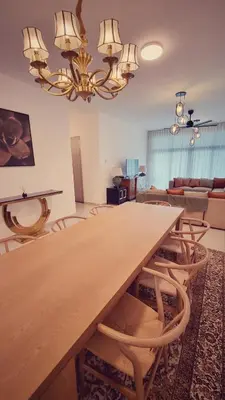 a dining room with a large wooden table and chairs at KLCC Legasi Executive Suite Apartment in Kuala Lumpur