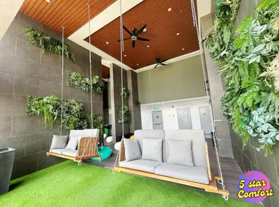 a patio with a white couch and some plants at 5 Star Comfort Riveria City KL Sentral 4 pax infinity pool in Kuala Lumpur