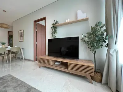 a living room with a television on a wooden entertainment center at Sky Suites Charming 3BR Suite KLCC View in Kuala Lumpur