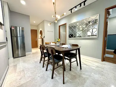 a dining room with a table and a refrigerator at Sky Suites Deluxe 3BR Suite at KLCC in Kuala Lumpur