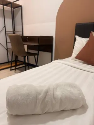 a white blanket on a bed with a table at Downtown Retreat 2BR at Neu Suites, Kuala Lumpur in Kuala Lumpur