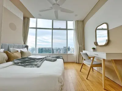 a bedroom with a bed and a desk and a window at Sky Suites Upper 3BR Suite at KLCC in Kuala Lumpur