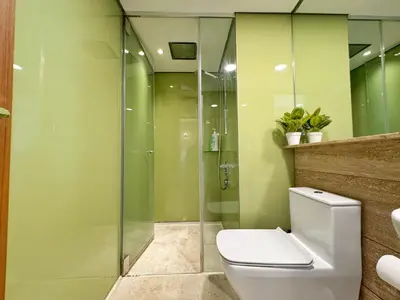 a bathroom with a toilet and a glass shower at Sky Suites Upper 3BR Suite at KLCC in Kuala Lumpur