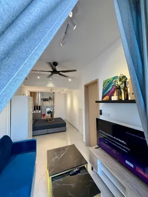a living room with a couch and a tv at Klcc view residences in Kuala Lumpur