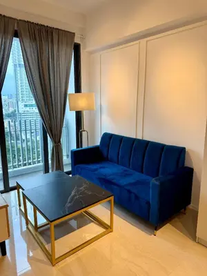 a living room with a blue couch and a table at Klcc view residences in Kuala Lumpur