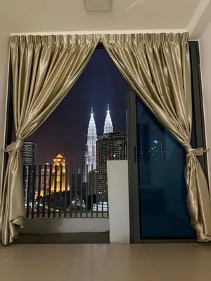 a window with a view of the city at night at Klcc view residences in Kuala Lumpur