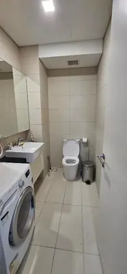 a bathroom with a toilet and a sink and a washing machine at City Centre Apartment in Kuala Lumpur