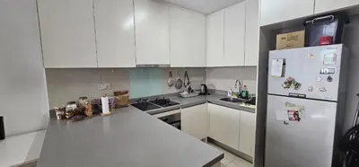 a kitchen with white cabinets and a white refrigerator at City Centre Apartment in Kuala Lumpur