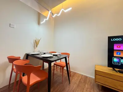 a dining room with a black table and orange chairs at X - The Thomas Bangsar South Midvalley LRT Kerinchi in Kuala Lumpur