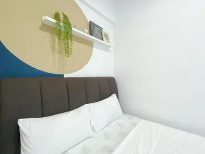a bedroom with a bed and a plant on a shelf at The colony by infinitum sweet home in Kuala Lumpur