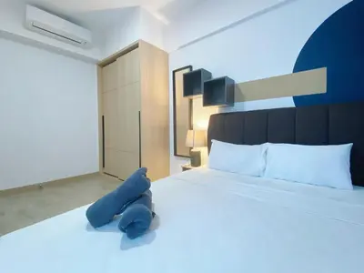 a blue teddy bear laying on a bed at The colony by infinitum sweet home in Kuala Lumpur