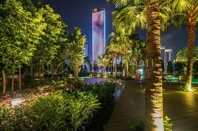 a view of a building with palm trees at night at Agile Premier Suites Kuala Lumpur in Kuala Lumpur