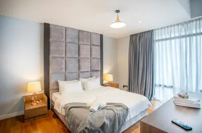 a bedroom with a large bed and a desk at Anggun Residence near KLCC in Kuala Lumpur