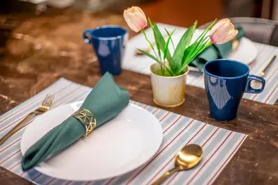 a table with a plate with a green napkin and fork and spoon at Anggun Residence near KLCC in Kuala Lumpur