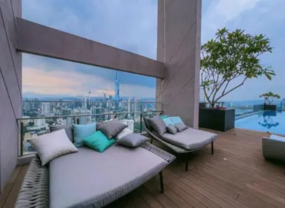 a balcony with a couch and a view of a city at The Riv at Riveria City KL Sentral by Luxe n Comfy in Kuala Lumpur