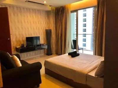 a bedroom with a bed and a tv and a couch at Regalia residency in Kuala Lumpur