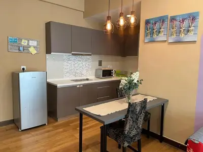 a small kitchen with a table and a refrigerator at Regalia residency in Kuala Lumpur