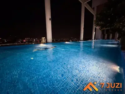 a dolphin swimming in a swimming pool at night at Premium&Cozy Studio small cinema KLCC InfinityPool in Kuala Lumpur