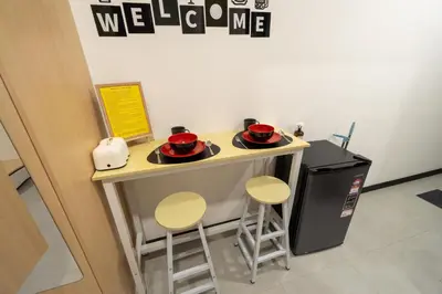 a small kitchen with a counter with two stools at Neu Suites By Cozy Unit L30RA 2-3PAX near KLCC & Jelatek LRT in Kuala Lumpur