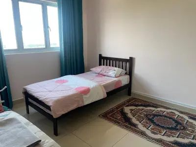 a small bedroom with a bed and a rug at Azmaya homestay in Kuala Lumpur