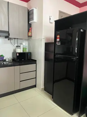 a kitchen with a black refrigerator and a microwave at Azmaya homestay in Kuala Lumpur