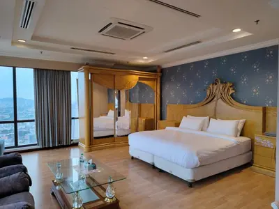 a bedroom with a large bed and a glass table at Penthouse Duplex with KLCC Views At Times Square in Kuala Lumpur