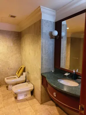 a bathroom with a sink and a toilet and a mirror at Penthouse Duplex with KLCC Views At Times Square in Kuala Lumpur