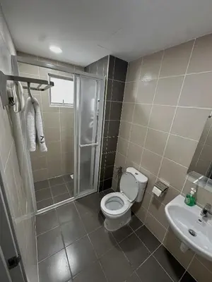 a bathroom with a toilet and a shower and a sink at Razak City Residences in Kuala Lumpur